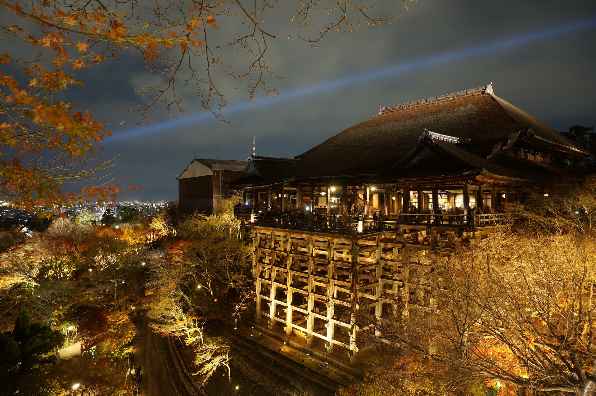 A picture of Kiyomizu-dera temple at night, illuminated with warm lights.