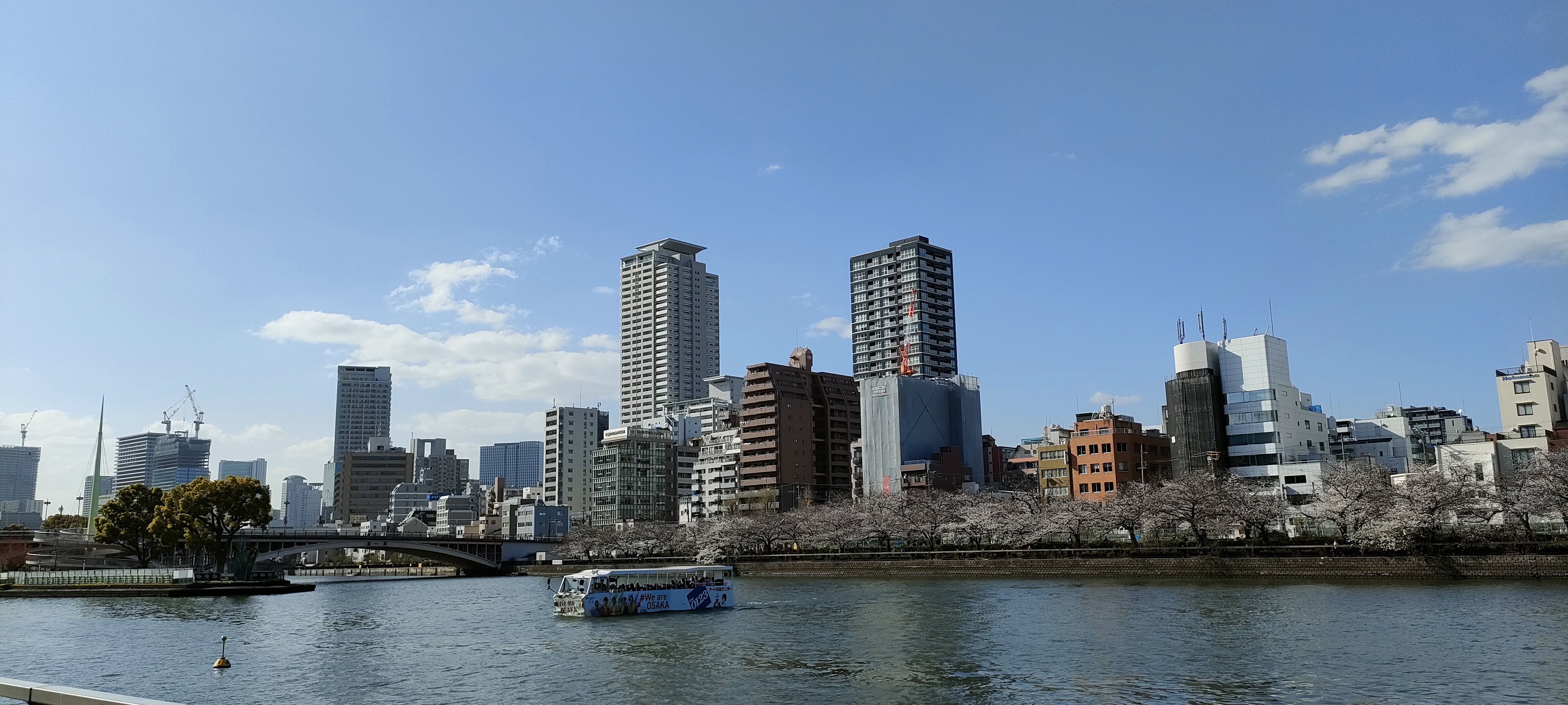 Bridge-view of Hachikenya Pier with Temmabashi Station and a ferry in view.